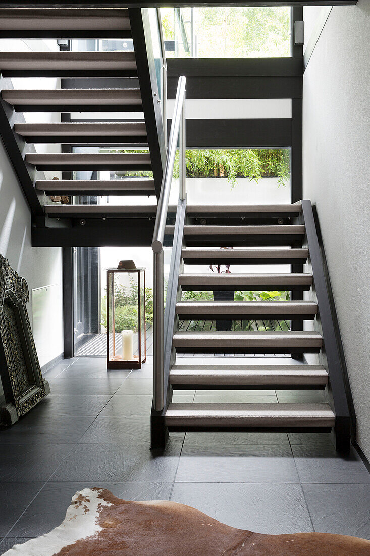 Ponyskin rug with open tread staircase in contemporary SW London home, England, UK