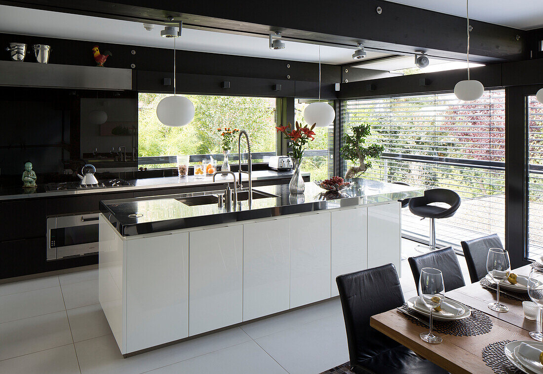 Edelstahl-Arbeitsplatten in offener Küche und Esszimmer in einem modernen Haus im Südwesten Londons, England, UK