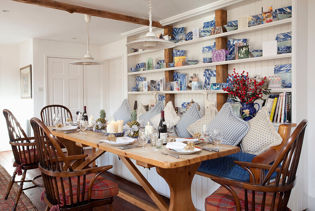 Esstisch mit Schottenkaro-Sitzkissen und offenen Regalen in einem Haus in den Chilterns England UK