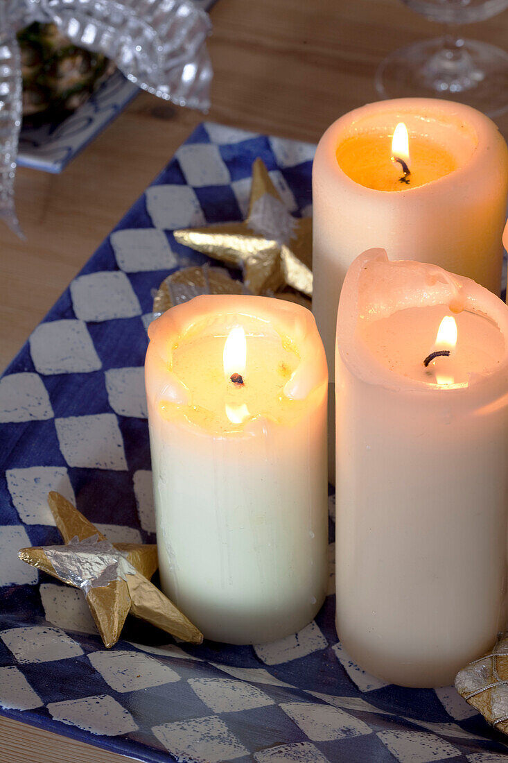Lit candle on blue and white tray with star shaped ornament in Chilterns home, England, UK