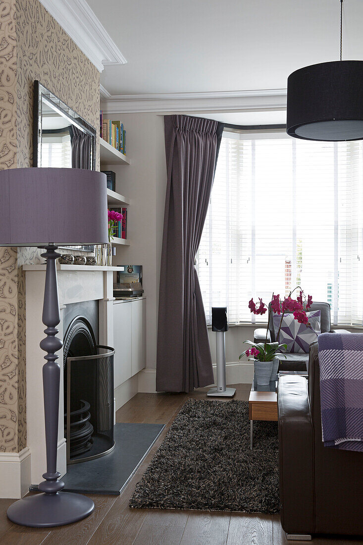 Lilac standard lamp at fireside of contemporary living room Brighton home, East Sussex, England, UK