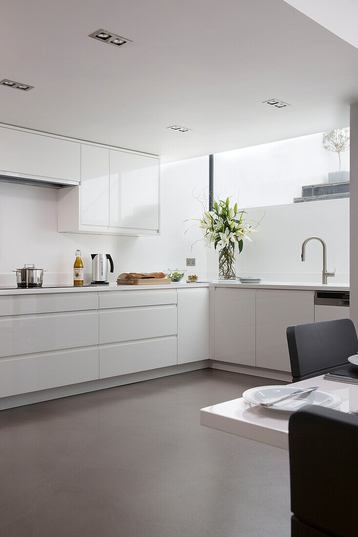 Polished floor in white fitted kitchen of contemporary Brighton home, East Sussex, England, UK