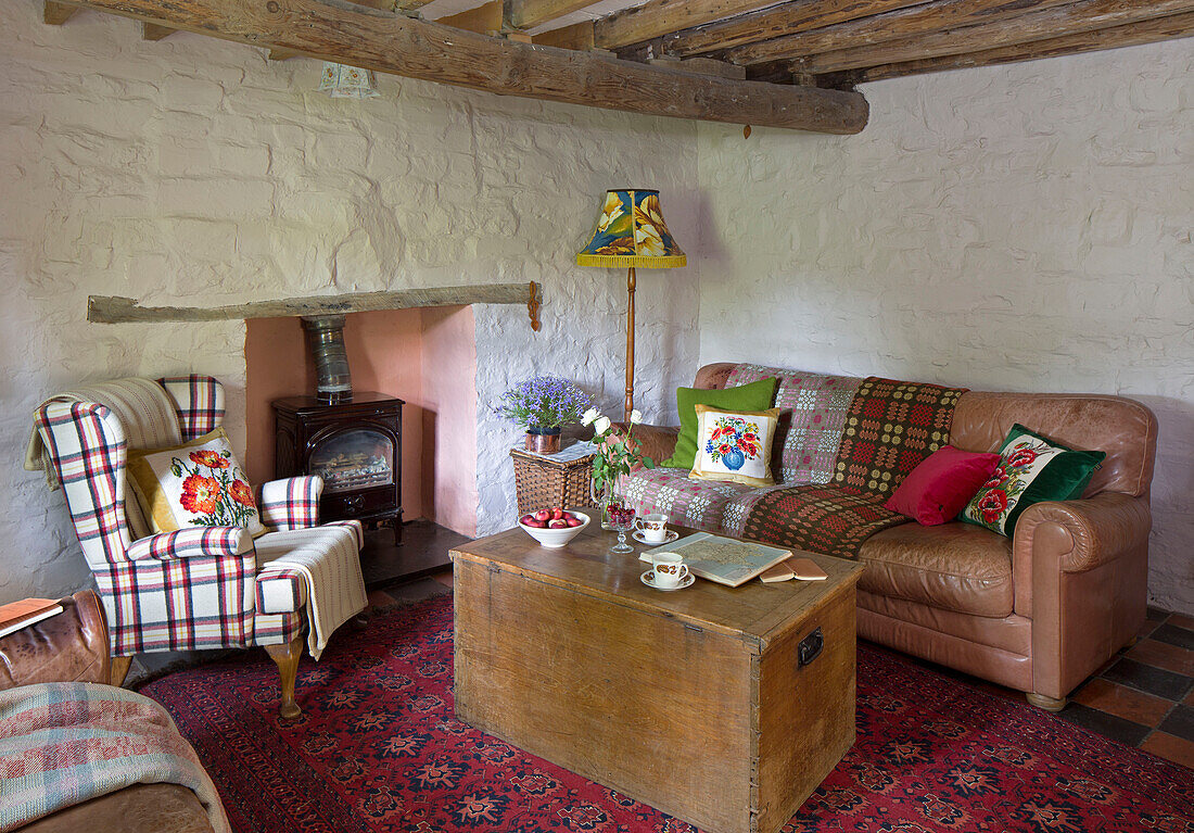 Holzkiste mit Sessel und Sofa im Wohnzimmer eines Cottage in Ceredigion, Wales UK