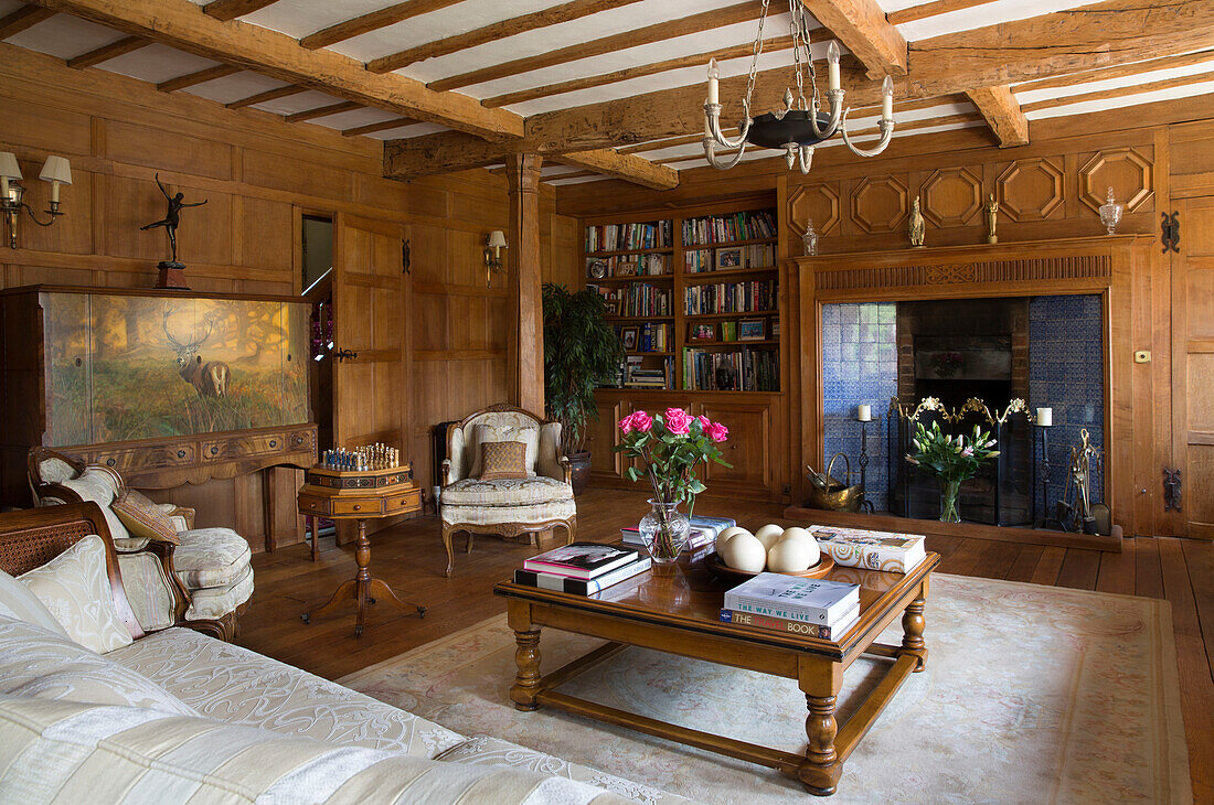 Holzgetäfeltes Wohnzimmer mit niedrigem Couchtisch und Kachelofen in einem Haus in London, UK