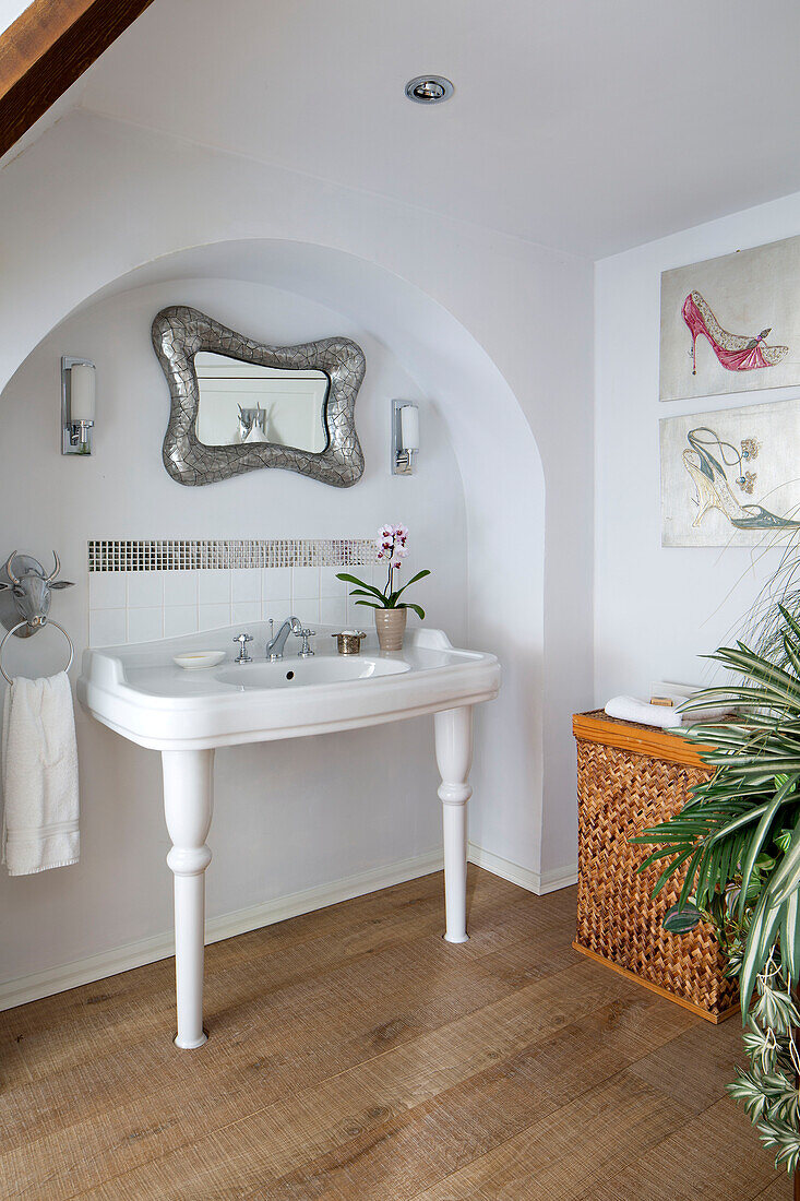 White ceramic washbasin in arched recess of London bathroom, UK