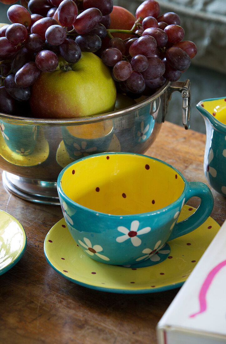 Geblümte Teetasse mit einer Schale Weintrauben auf einem Holztisch in Camber cottage East Sussex England UK