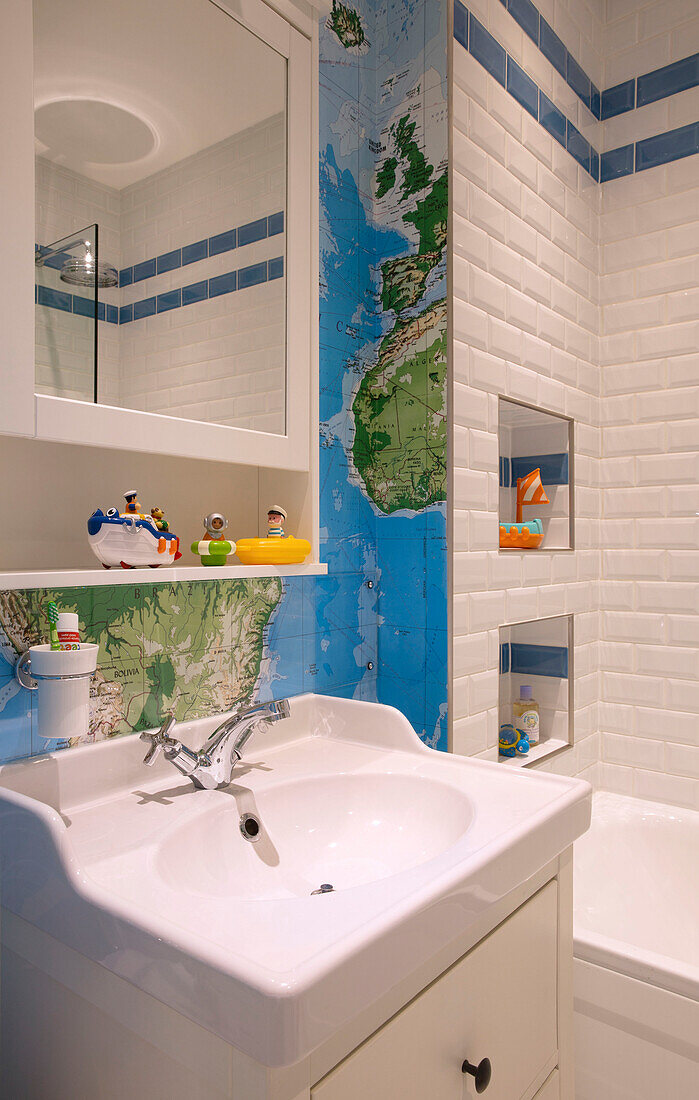 Wandkarte und Badespielzeug im gefliesten Badezimmer eines Londoner Stadthauses, England, UK