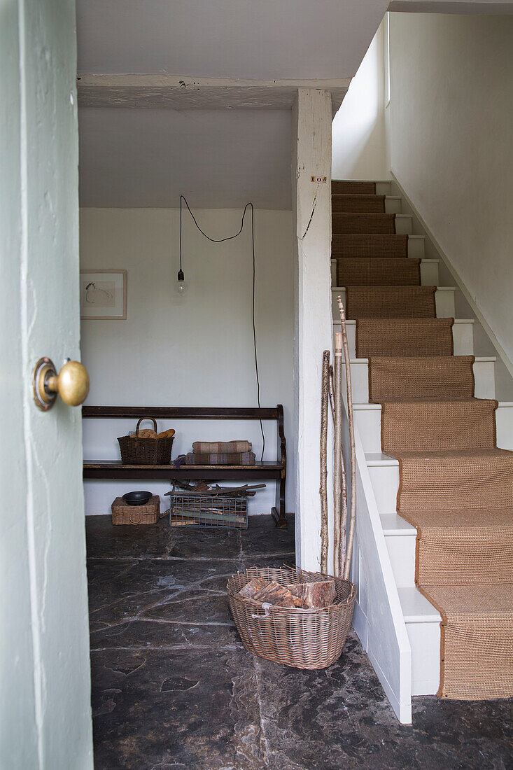 Korb mit Holzscheiten und Teppichboden in der Eingangshalle eines Hauses in Presteigne, Wales UK