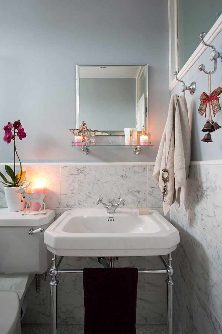 Handtuchhaken über dem Waschbecken mit Marmorverkleidung im grauen Badezimmer eines Hauses in London, England, UK