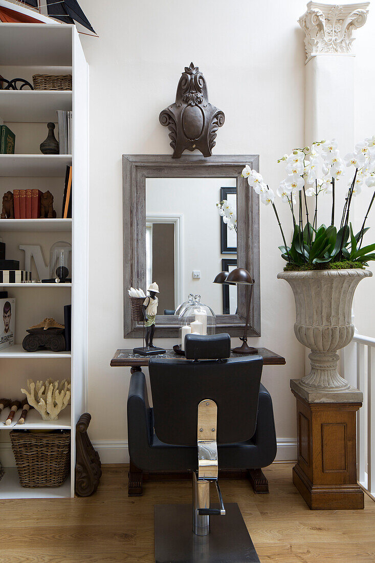 Black leather armchair with large houseplant in front of mirror in Twickenham townhouse, Middlesex, England, UK