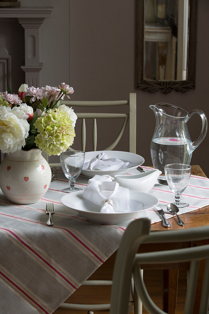 Gestreifte Tischdecke auf einem Esstisch mit Servietten auf Schalen in einem britischen Haushalt