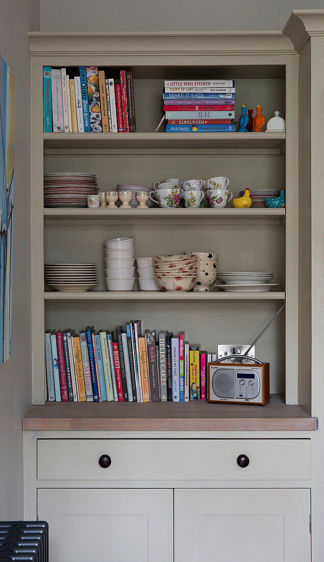 Books and crockery with radio on kitchen dresser in Shoreham by Sea home   West Susses   England   UK