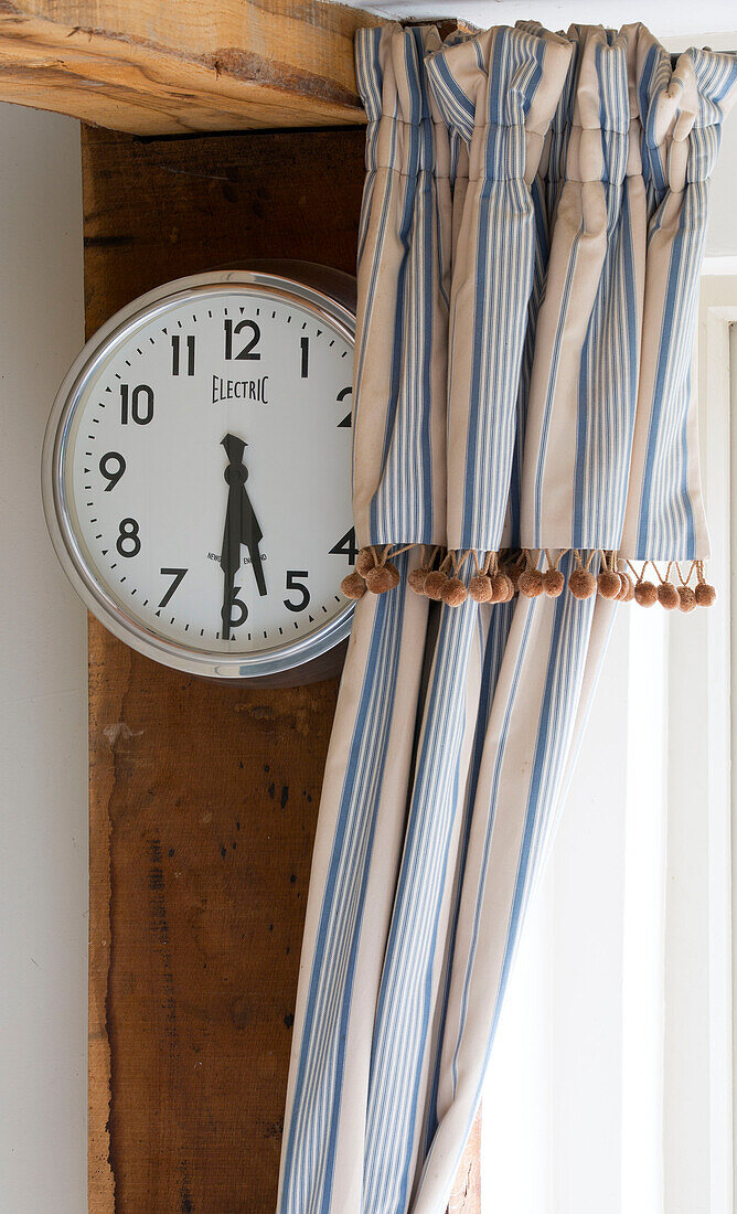 Striped curtains and clock face in Suffolk kitchen,  England,  UK