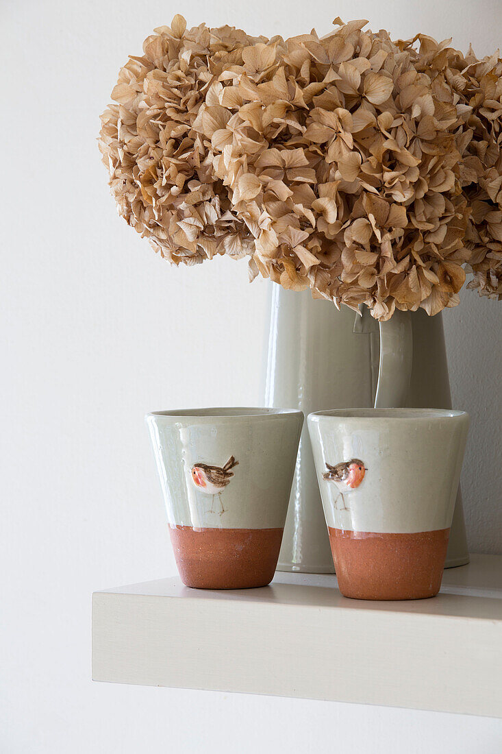 Getrocknete Hortensien mit Keramiktassen in einem Bauernhaus in Suffolk, England, UK