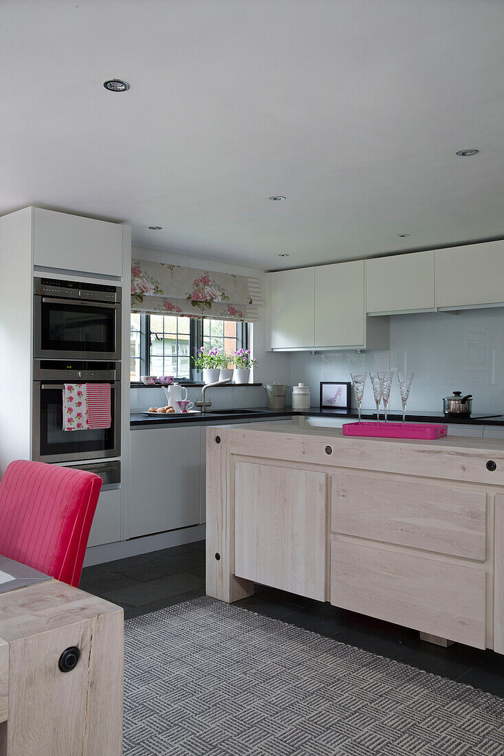 Kücheninsel aus hellem Holz mit integriertem Backofen im Landhaus in Sussex, England UK