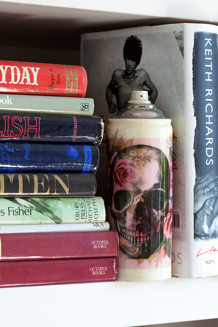 Verschiedene Bücher mit Totenkopf auf Sprühdose in Londoner Stadthaus, England, UK
