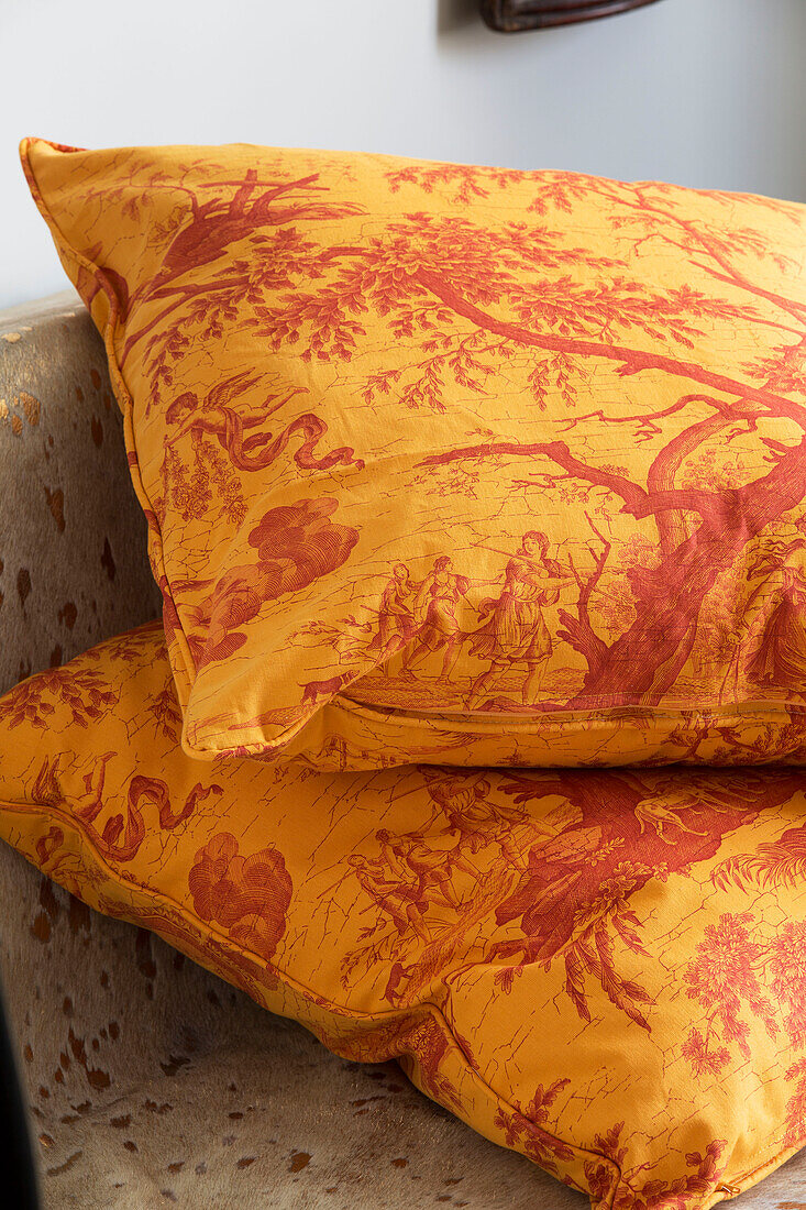 Oriental yellow and red patterned cushions in London home, England, UK