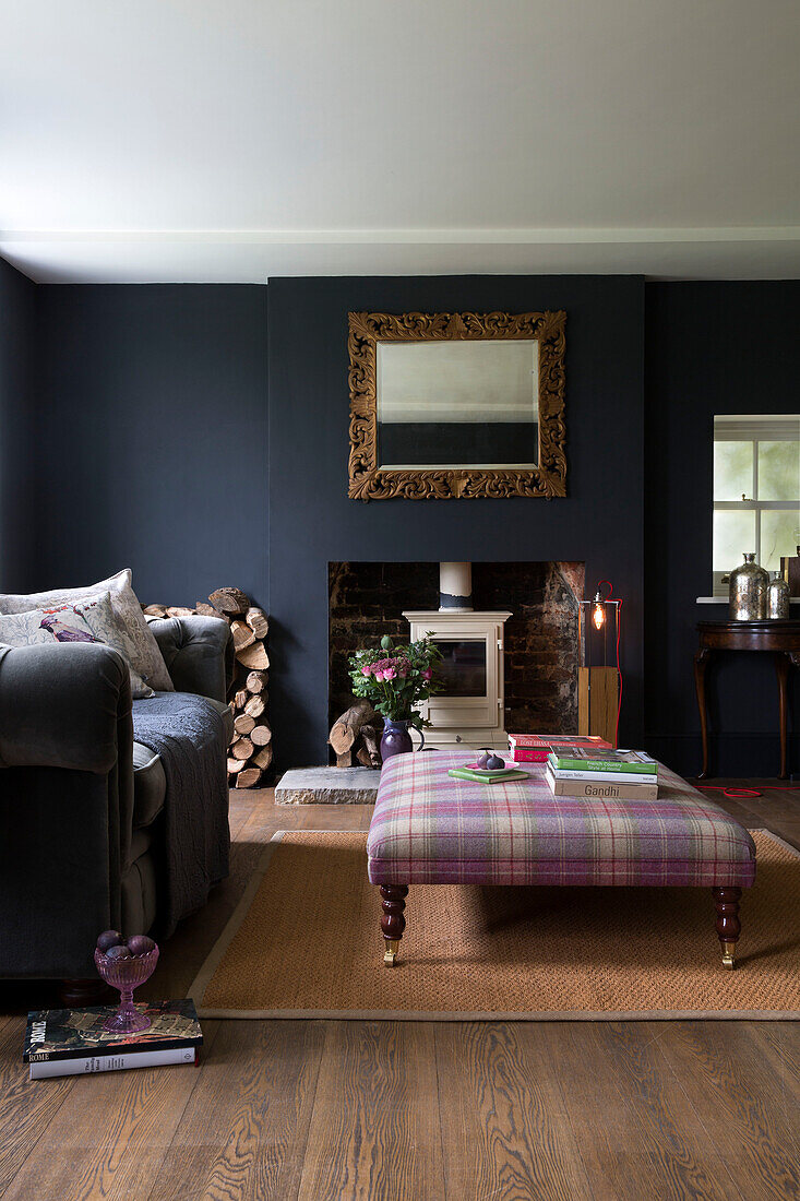 Tartan ottoman with grey sofa and carved wooden mirror in Sussex living room UK