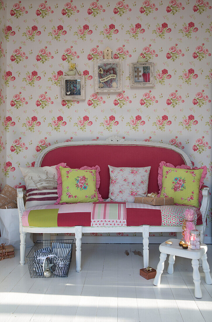 Pink couch with floral cushions and wallpaper in Laughton home  Sheffield  UK