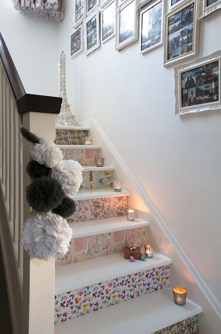 Gerahmte Fotos über einer tapezierten Treppe mit brennenden Kerzen in einem Haus in Laughton Sheffield UK