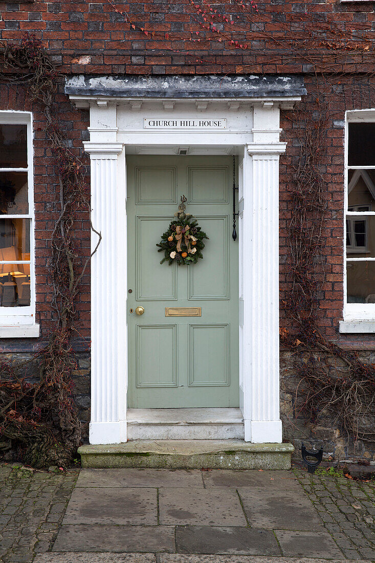 Weihnachtsgirlande an hellgrüner Eingangstür eines Hauses in Sussex England UK