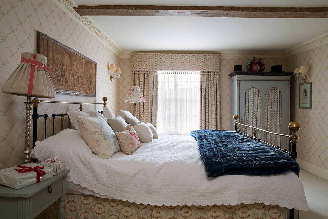 Blue velvet quilt folded on double bed in Sussex home  England  UK