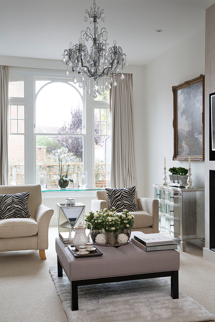 Paar Sessel und Ottomane in einem Wohnzimmer mit Bogenfenster in einem modernen Londoner Haus UK
