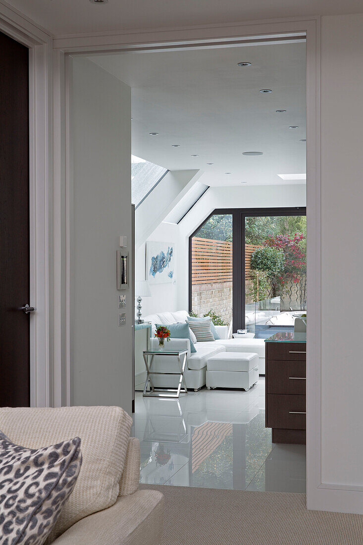 Blick durch die Tür zum weißen Sofa in einer modernen Londoner Wohnung UK