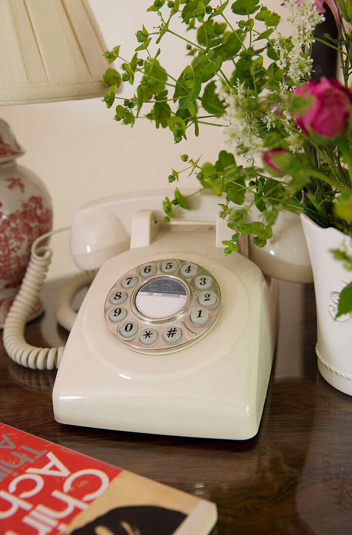 Telefon mit Wählscheibe auf poliertem Holztisch in einem britischen Bauernhaus