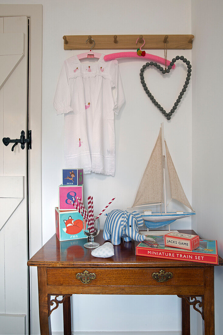 Toys on side table below wooden pegboard in London home,  England,  UK
