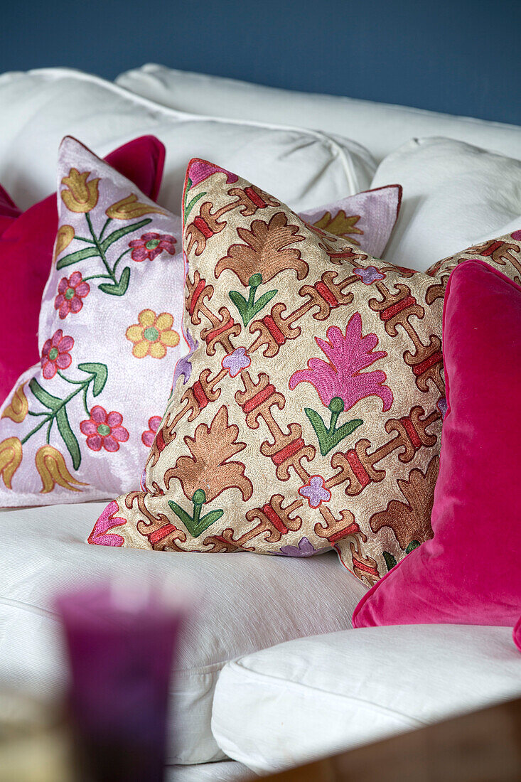 Assorted cushions on white sofa in London home,  England,  UK