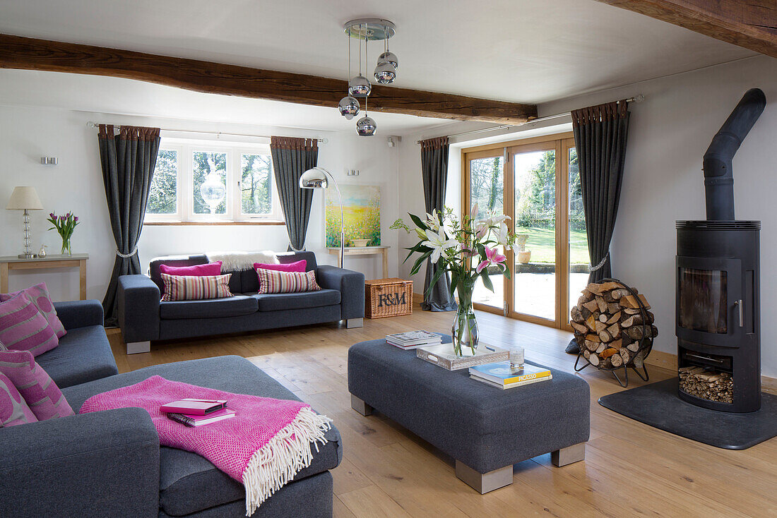 Rosa Decke und Kissen im Wohnzimmer mit grauen Möbeln Warminster Landhaus Wiltshire England UK