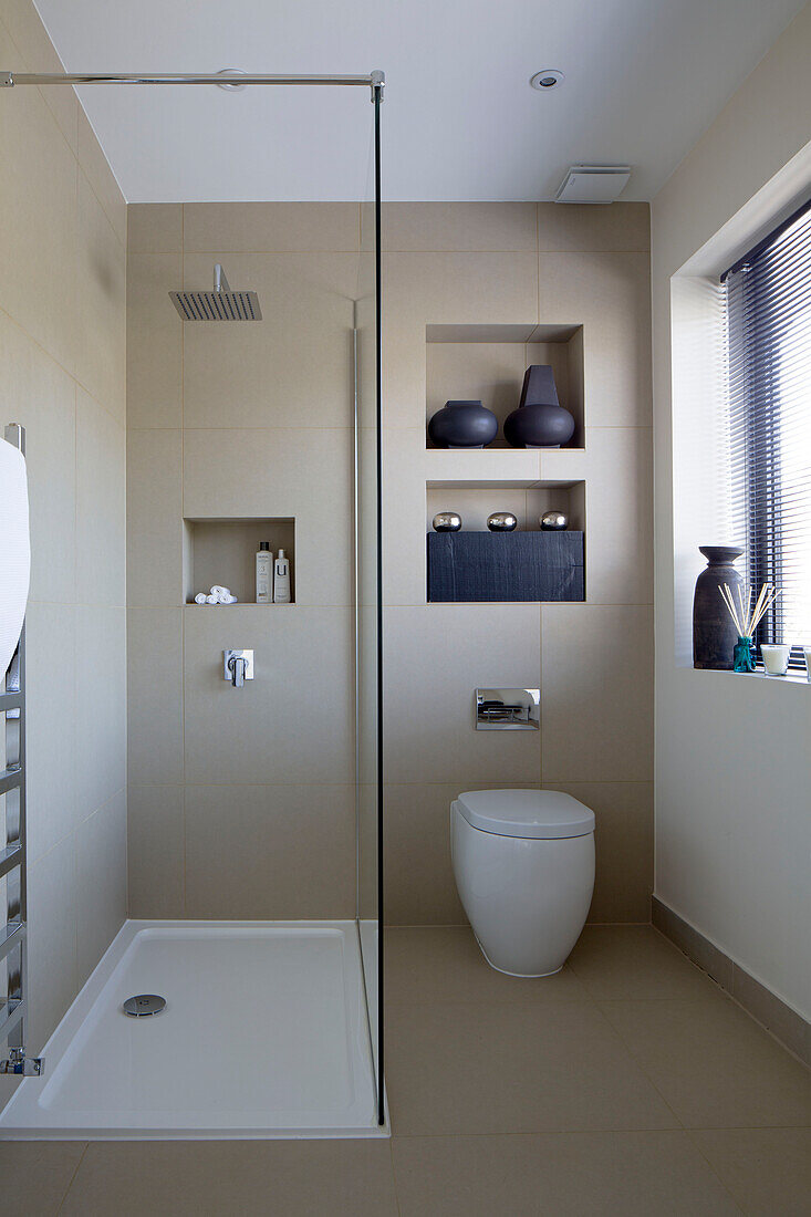 Duschkabine mit eingelassenen Regalen in einem Badezimmer im Zen-Stil in einem Haus in London, England, UK