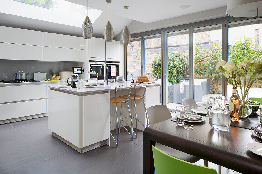 Pendelleuchten über der Frühstücksbar in offener Küchenerweiterung eines modernen Hauses in London, England, UK