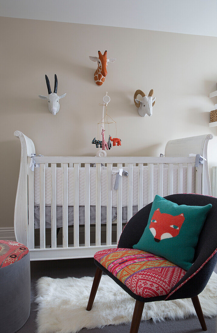 Fuchskissen auf Sessel mit Kinderbett im Kinderzimmer eines Hauses in London, England, Vereinigtes Königreich