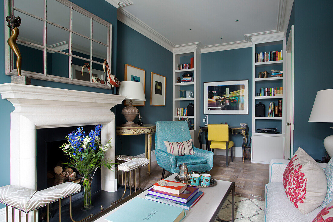 Cut flowers in fireplace of London living room with retro styled chairs, England, UK