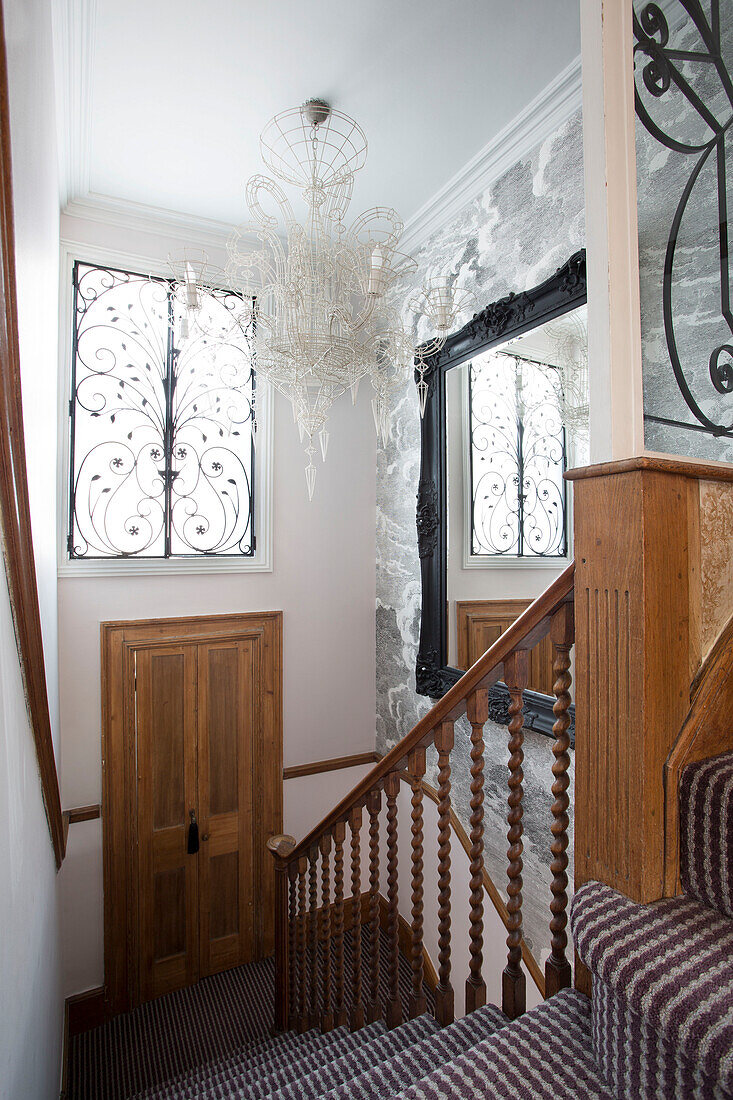 Holzgeländer und Treppenhaus mit Teppichboden und Fenstergitter in einem Londoner Stadthaus England UK