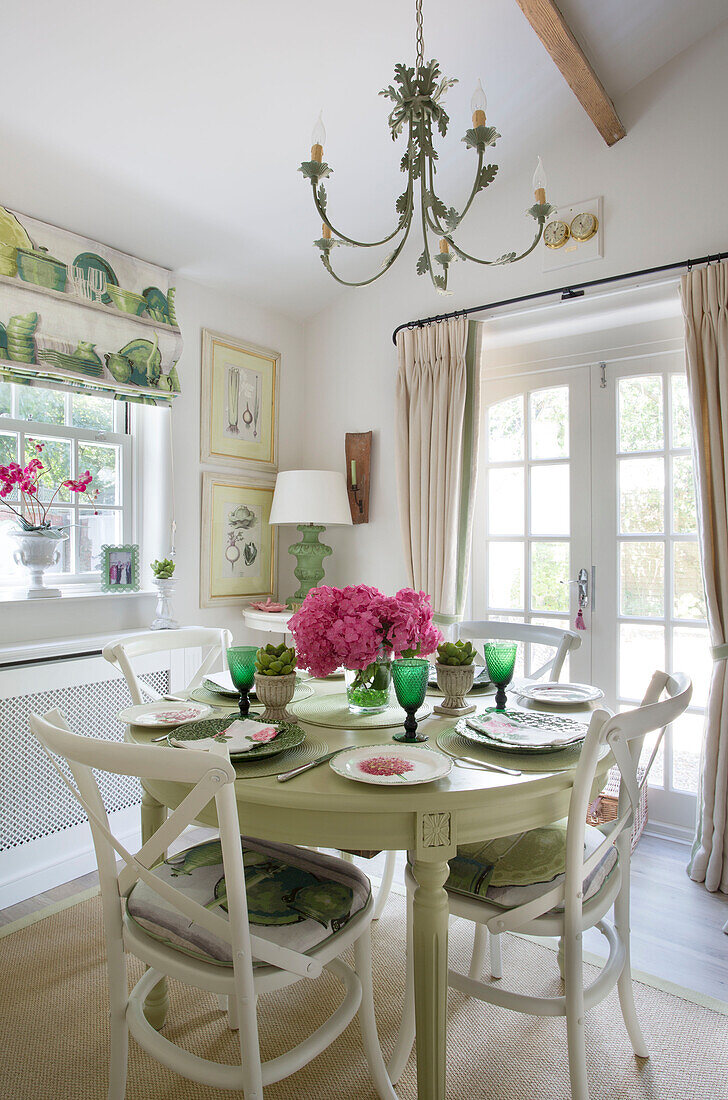 Hellgrüner Esstisch mit Terrassentüren in einem Haus in Dorset, England, UK