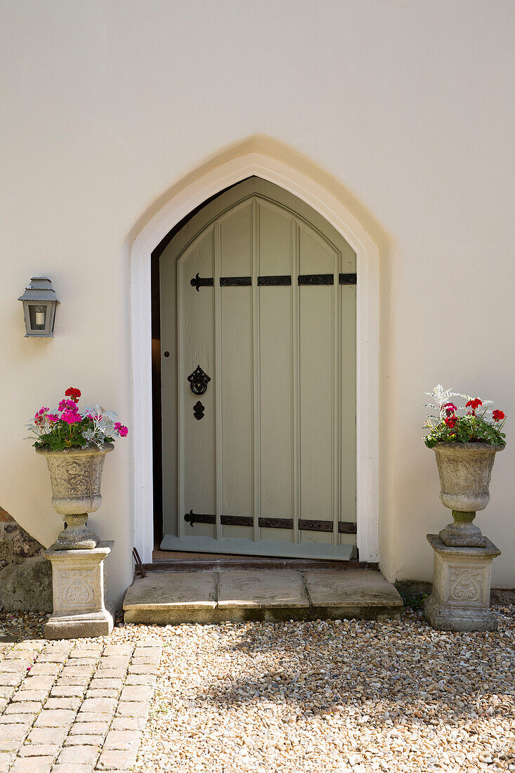 Arched doorway and garden planters at exterior of Dorset home England UK