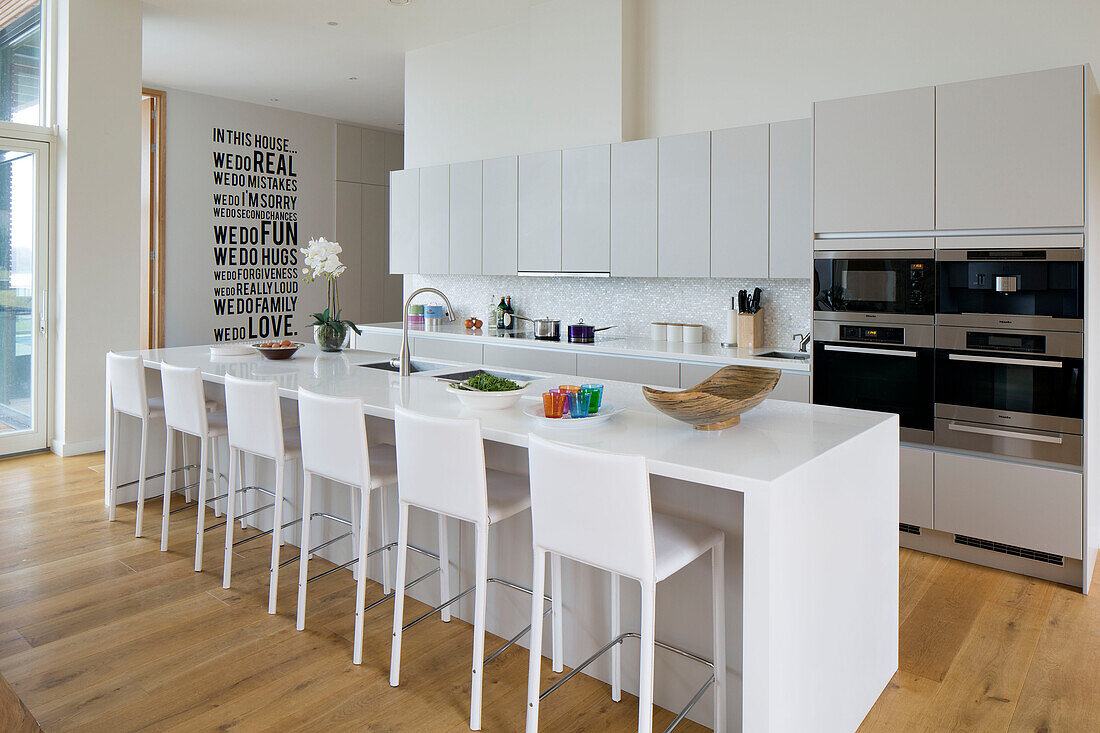 White barstools at breakfast bar in Lechlade kitchen Gloucestershire England UK