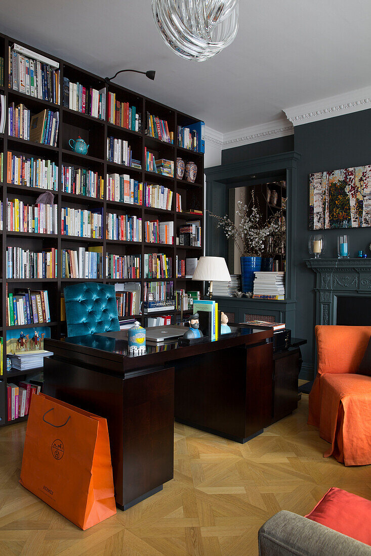 Dark wooden desk and bookcase in London townhouse UK