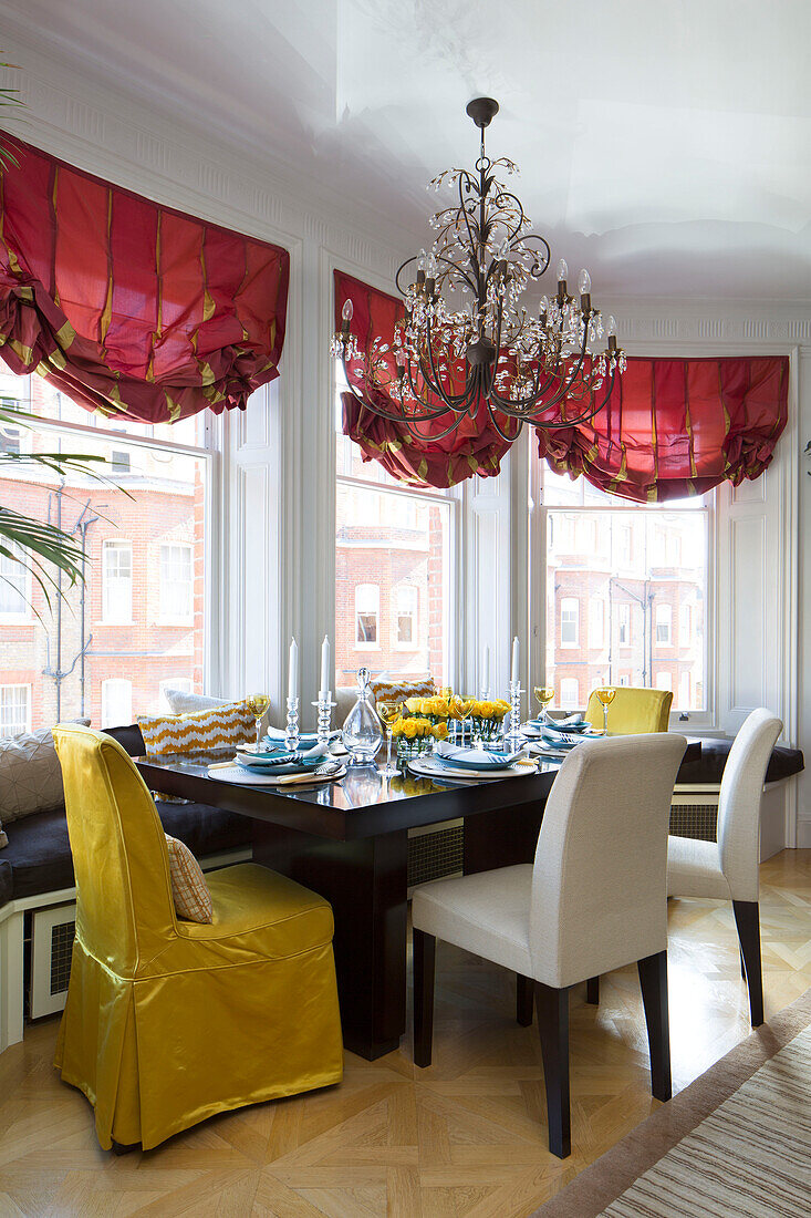 Goldene und cremefarbene Esszimmerstühle am Tisch mit Fensterplatz in einem Londoner Stadthaus UK
