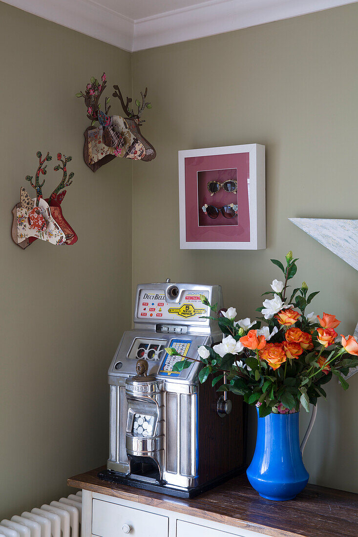 Rentierköpfe und Obstmaschine mit Schnittblumen auf einer Konsole in einem britischen Haus