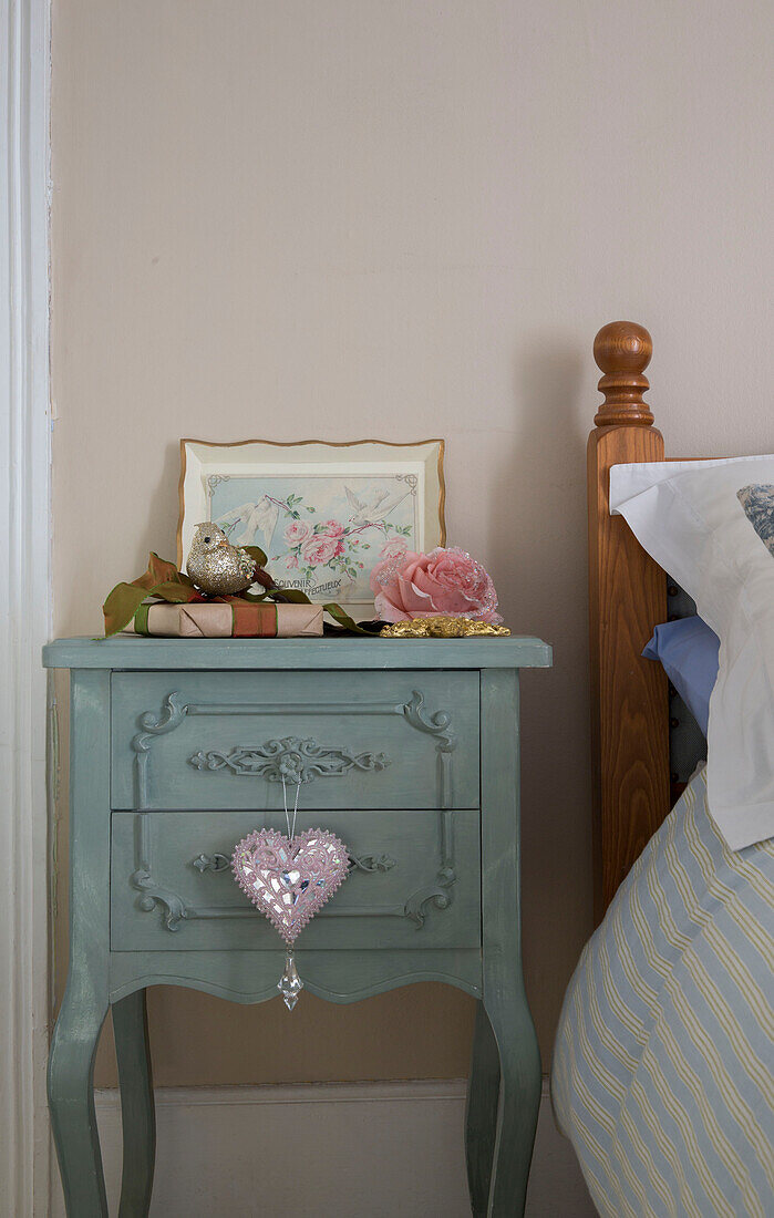 Heart shaped ornament on painted bedside table in London home England UK