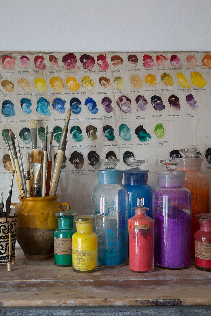 Assorted paint colours and brushes in Arundel studio West Sussex England UK