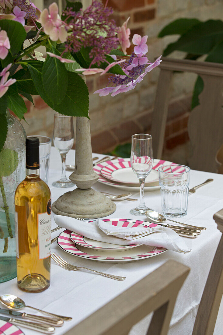 Weißwein und Gedeck auf einem Esstisch in einem Haus in West Sussex, England, Vereinigtes Königreich