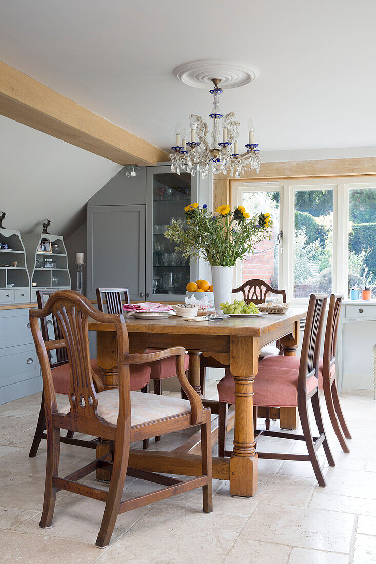 Wooden table for six with cut sunflowers in Grade II listed cottage in Hampshire England UK