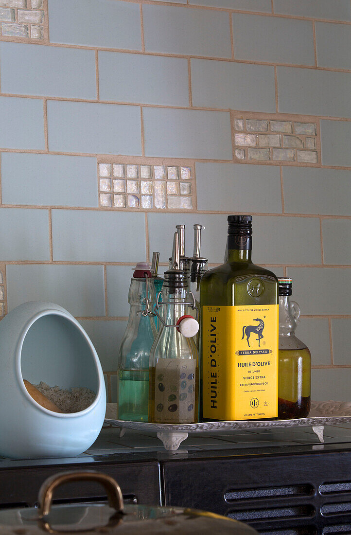 Olivenöl und Dressings mit Zuckerdose in der gefliesten Küche eines unter Denkmalschutz stehenden Cottage in Hampshire England UK