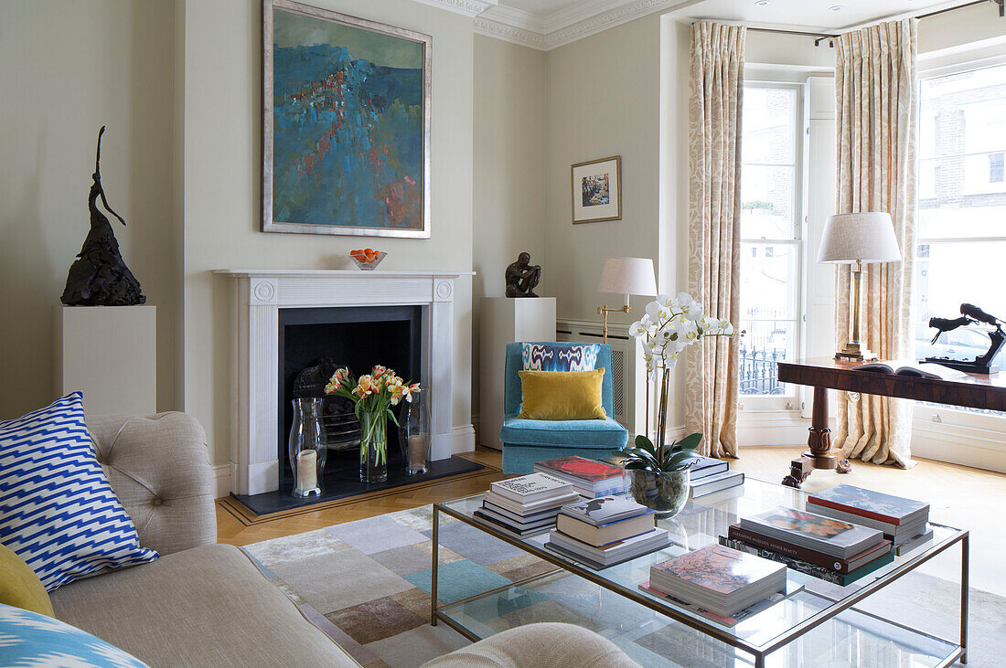 Modernes Kunstwerk mit Orchidee und Büchern im Wohnzimmer eines viktorianischen Reihenhauses London England UK