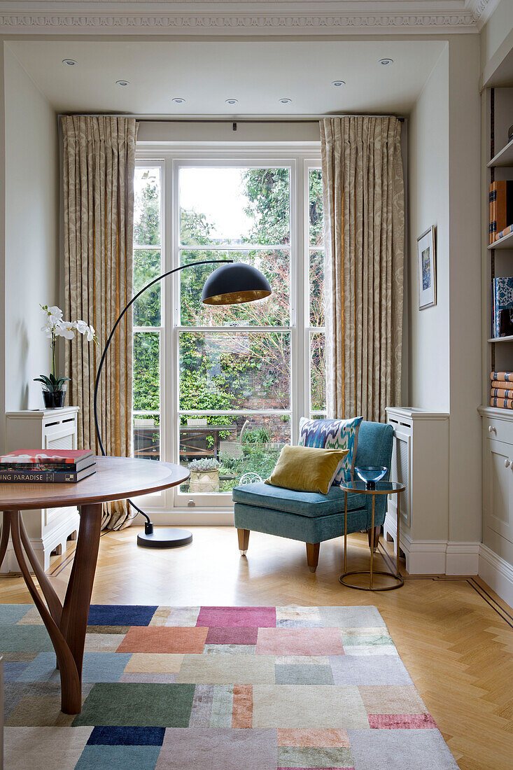 Schwarze Lampe und Stuhl am Gartenfenster in viktorianischem Reihenhaus London England UK